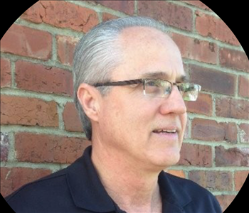 Man in front of brick wall 